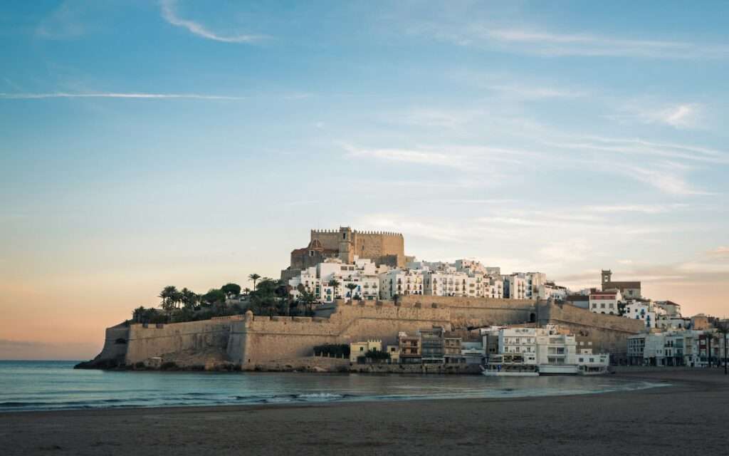 The walled old town of Peníscola on its rock above the beach at dawn